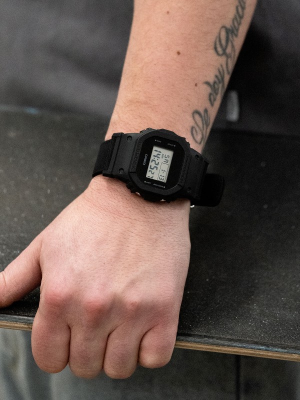 Otkrijte G-SHOCK "Origin" DW-5600BCE-1ER - ikonični muški sat sa crnom platnenom narukvicom i robustnim pravougaonim dizajnom.
