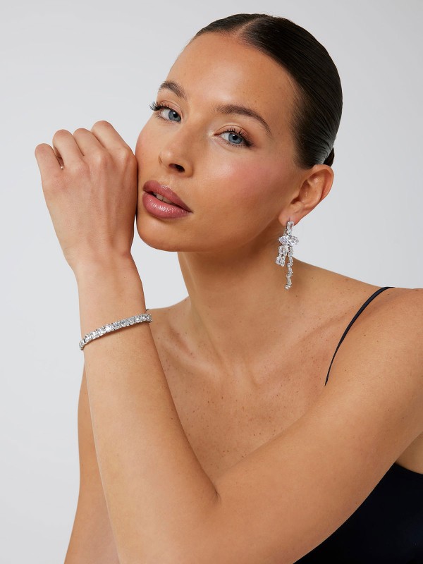 Guess ženska čvrsta narukvica Chandelier u boji srebra sa pravougaonim kristalima. Elegantna narukvica modernog dizajna, savršena za večernje i posebne prilike.