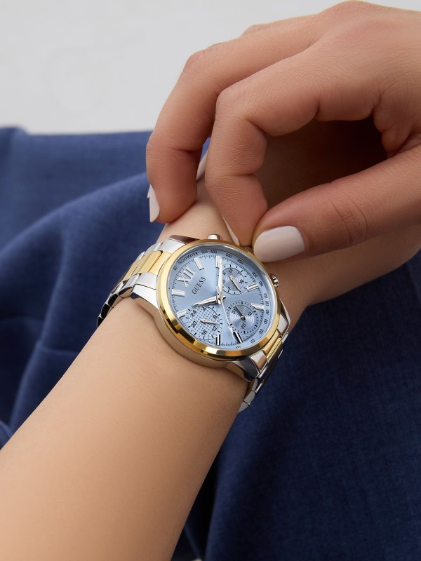 GUESS BAILEY ženski multi-function sat u kombinaciji srebra i žutog zlata sa svetloplavim sunray brojčanikom. Kućište 36 mm, elegantna narukvica sa tri linka, vodootpornost 30 m.