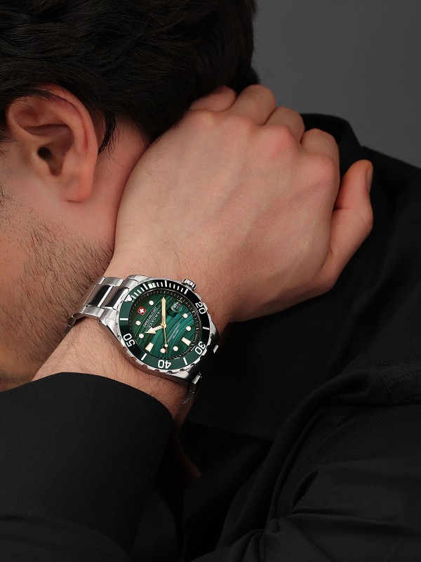 SWISS MILITARY HANOWA OFFSHORE DIVER GREEN WATER SMWGH0005804 – limitirani Swiss Made muški ronilački sat inspirisan smaragdnim vodama švajcarske reke Verzaska. Sat ima robusno kućište od nerđajućeg čelika prečnika 44 mm, zeleni malahitni brojčanik i čeličnu narukvicu. Sa vodootpornošću do 200 metara, safirnim staklom i kvarcnim mehanizmom Ronda 715, ovaj model spaja vrhunsku preciznost i ekskluzivan dizajn.