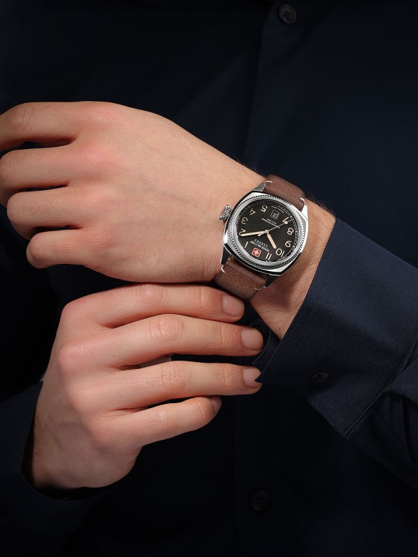 SWISS MILITARY HANOWA CONDOR SMWGB0003701 – Swiss Made muški sportski sat inspirisan avijacijom. Kućište od nerđajućeg čelika u boji srebra, crni brojčanik sa osvetljenim oznakama i braon kožna narukvica stvaraju spoj robustnosti i elegancije. Sat pokreće švajcarski kvarcni mehanizam Ronda 515, sa safirnim staklom i vodootpornošću do 100 metara.