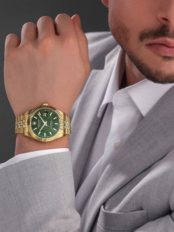 SWISS MILITARY HANOWA MASTER DILIGENTER SMWGL0005412 – luksuzni Swiss Made automatik sat koji spaja eleganciju i izdržljivost. Kućište od nerđajućeg čelika u boji žutog zlata (41 mm) sa žlebljenim okvirom i teksturiranim zelenim brojčanikom stvara upečatljiv kontrast. Sat pokreće precizan automatski mehanizam Soprod P024, ima safirno staklo, uvećavajuće sočivo za datum i vodootpornost do 100 metara. Idealan izbor za muškarce koji žele prestižan izgled i švajcarsku pouzdanost.