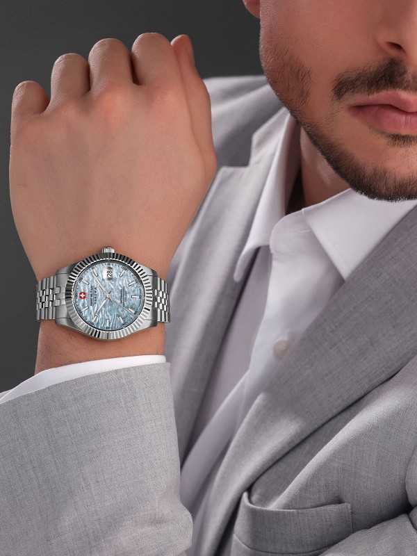 SWISS MILITARY HANOWA MASTER DILIGENTER SMWGL0005405 – Swiss Made muški automatik sat koji spaja bezvremensku eleganciju i tehničku preciznost. Kućište od nerđajućeg čelika prečnika 41 mm sa žlebljenim okvirom i teksturirani svetlo plavi brojčanik daju mu sofisticiran izgled. Sat pokreće automatski mehanizam Soprod P024, ima safirno staklo, uvećavajuće sočivo za datum i vodootpornost do 100 metara – idealan izbor za muškarce koji traže luksuz, pouzdanost i klasičan stil.