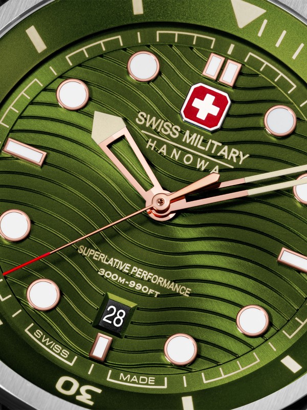 SWISS MILITARY HANOWA BREAKWATER SMWGN0006402 – Swiss Made muški sportski sat dizajniran za avanture pod vodom i na kopnu. Kućište od nerđajućeg čelika prečnika 43 mm i maslinasto zeleni brojčanik sa talasastim uzorkom daju mu robustan, a sofisticiran izgled. Maslinasto zelena silikonska narukvica pruža udobnost i sigurnost, dok safirno staklo, kvarcni mehanizam Ronda 505 i vodootpornost do 300 metara obezbeđuju pouzdanost u svim uslovima.