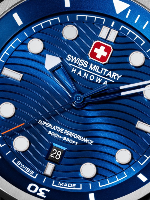 SWISS MILITARY HANOWA BREAKWATER SMWGH0006403 – Swiss Made muški sportski sat dizajniran za ekstremne uslove i dubine do 300 metara. Kućište od nerđajućeg čelika prečnika 43 mm, gradijentno plavi brojčanik sa talasastim uzorkom i safirno staklo pružaju savršenu kombinaciju funkcionalnosti i stila. Sat poseduje dve krunice sa zavrtnjem za podešavanje vremena i ronjenja, kao i kvarcni mehanizam Ronda 505 sa funkcijom datuma.