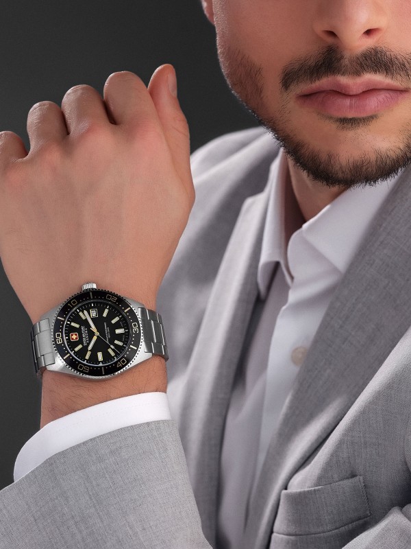 SWISS MILITARY HANOWA NOMAD SMWGH0004905 – Swiss Made muški sportski sat koji spaja vintage estetiku sa modernom elegancijom. Kućište od nerđajućeg čelika i crni brojčanik sa suptilnim zlatnim detaljima stvaraju luksuzan kontrast. Safirno staklo, kvarcni mehanizam Ronda 515 i vodootpornost do 100 metara čine ga pouzdanim izborom za muškarce koji cene preciznost i prefinjen stil.