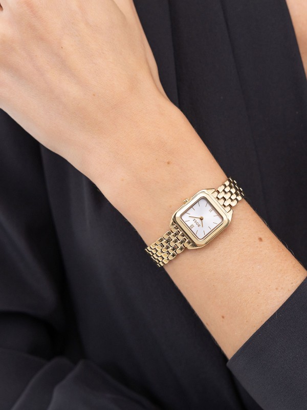 BOSS MAE PETITE 1502823 – moderan ženski sat koji spaja klasičnu eleganciju i savremeni dizajn. Kućište manjih dimenzija od nerđajućeg čelika u boji žutog zlata sa srebrno belim brojčanikom i rimskim brojevima odiše luksuzom i profinjenošću. Vodootpornost do 30m, mineralno staklo i kvarcni mehanizam čine ovaj model savršenim izborom za dame koje preferiraju sofisticiran, minimalistički stil.