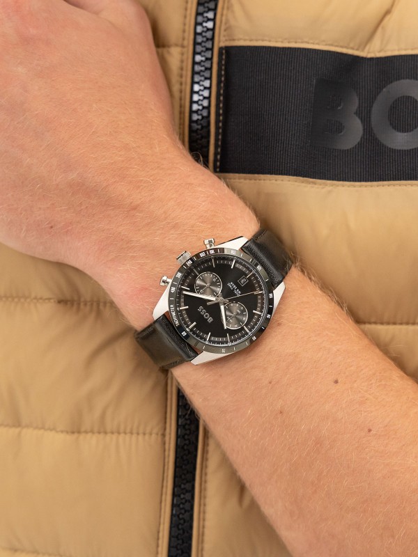 BOSS TOURMASTER 1514284 – muški sat sa dualnim vremenom i crnim “panda” brojčanikom. Kućište od nerđajućeg čelika sa crnim tahimetarskim okvirom, kupolasto staklo i crna kožna narukvica. Savršen spoj retro šarma i moderne preciznosti.