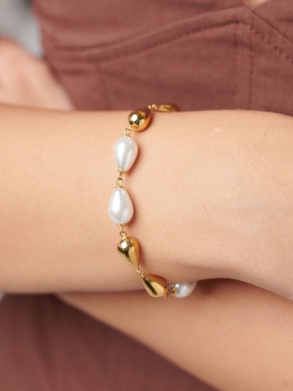 Brosway PERFECT ženska narukvica od nerđajućeg čelika u boji žutog zlata kombinuje bisere i čelične perle u obliku kapljice. Elegantna i profinjena, idealna za svaku priliku i savršen dodatak sofisticiranom stilu. Dužina: 20 cm.