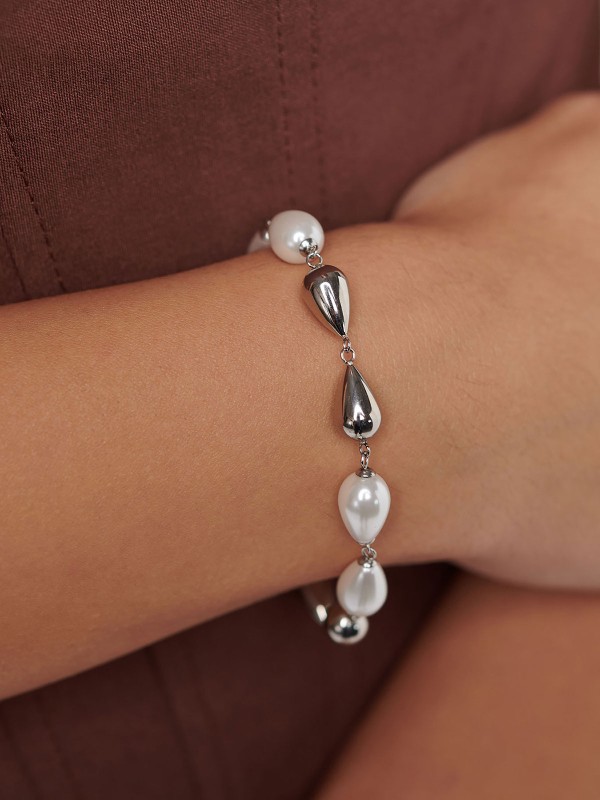 Brosway PERFECT ženska narukvica izrađena od nerđajućeg čelika u boji srebra, ukrašena biserima i čeličnim perlama u obliku kapljice. Suptilna elegancija i bezvremenski sjaj koji upotpunjuju svaku kombinaciju. Dužina: 20 cm.