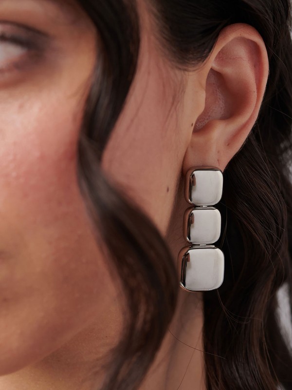 Brosway MUSE viseće minđuše u boji srebra izrađene su od nerđajućeg čelika i ukrašene nizom od tri elegantna kvadrata. Moderan i prefinjen dizajn koji donosi suptilnu eleganciju i savršen završni detalj svakoj odevnoj kombinaciji.