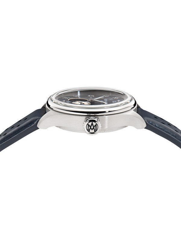 Aston Martin MTTS1F502 – luksuzni automatik sat koji kombinuje eleganciju i tehničku preciznost. Kućište od nerđajućeg čelika prečnika 41mm sadrži skeleton brojčanik u teget boji sa istorijskim logom Aston Martina iz 1913. godine. Transparentna poleđina otkriva automatski mehanizam sa rotorom u prepoznatljivoj podium zelenoj boji. Uparen sa teget kožnom narukvicom, ovaj model spaja britansku sofisticiranost i savremeni dizajn za istinske poznavaoce stila.