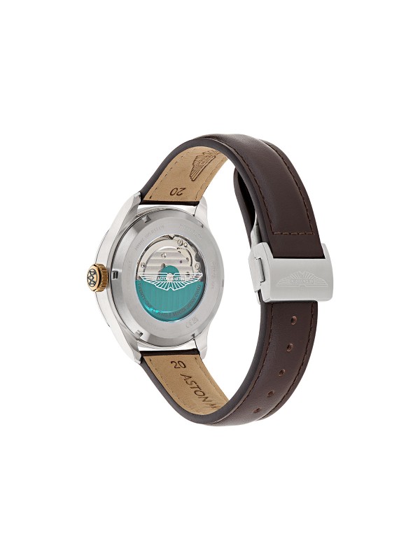 Aston Martin MTTS1F501 – automatik sat koji spaja luksuz, tradiciju i inženjersku preciznost. Kućište od nerđajućeg čelika prečnika 41mm sadrži skeleton brojčanik sa istorijskim Aston Martin logom iz 1913. godine, dok transparentna poleđina otkriva sofisticirani automatski mehanizam sa rotorom u podium zelenoj boji. Uparen sa braon kožnom narukvicom, ovaj sat odražava eleganciju i sportski duh, idealan za muškarce sa istančanim ukusom.