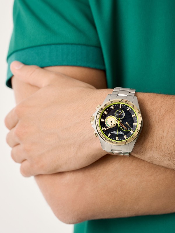 Aston Martin MTRH1F505 – muški hronograf sa kućištem od recikliranog nerđajućeg čelika prečnika 44mm i teget brojčanikom. Tahimetarska skala na okviru u boji žutog zlata, osvetljene kazaljke i prepoznatljivi detalji u boji limete čine ovaj sat simbolom sportske elegancije. Mineralno staklo sa safirnom prevlakom i vodootpornost do 100m garantuju pouzdanost i luksuz u svakom trenutku.
