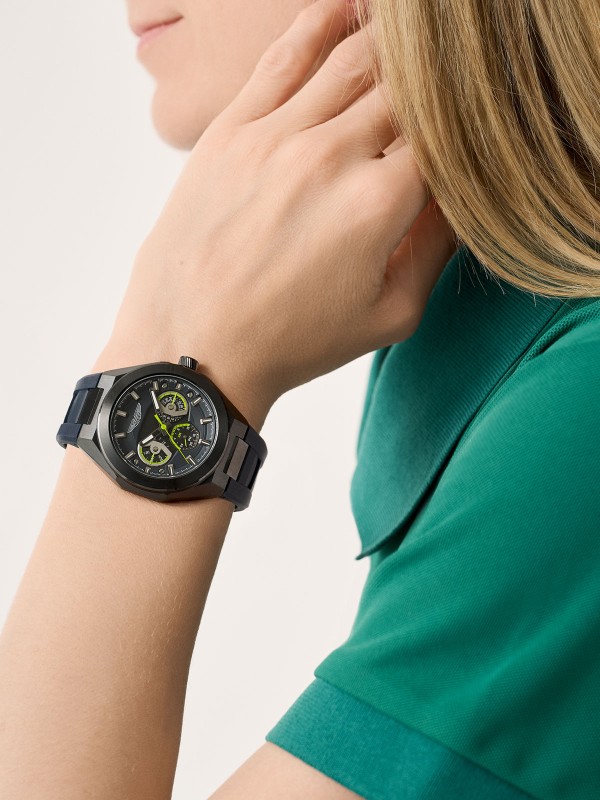 Aston Martin MTRI1F501 – muški multifunction sat sa kućištem od recikliranog nerđajućeg čelika u gun metal boji i teget silikonskom narukvicom. Teget brojčanik sa detaljima boje limete, mineralno staklo sa safirnom prevlakom i vodootpornost do 100m spajaju sportsku energiju i luksuznu estetiku Aston Martin brenda.