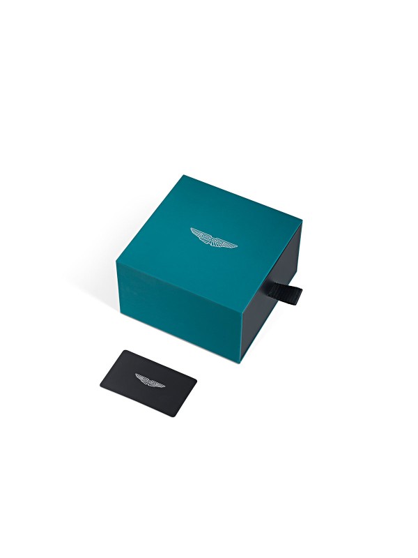 Aston Martin MTIZ1F503 – luksuzni muški GMT box set sat sa dve narukvice: čeličnom u boji srebra i silikonskom u prepoznatljivoj zelenoj Aston Martin boji. Crni brojčanik sa detaljima u podijum zelenoj i limeta boji ističe sportsko nasleđe i sofisticiran dizajn.