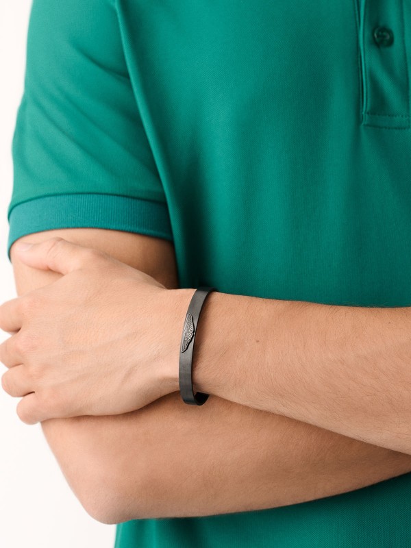 Aston Martin MJIBF5BM4 – muška čvrsta narukvica izrađena od brušenog nerđajućeg čelika 316L u gun metal boji. Ugravirana sa prepoznatljivim Aston Martin krilima, predstavlja savršen spoj luksuza, snage i elegancije. Simbol sofisticiranog britanskog stila i preciznosti. Dimenzije (veličina M): 65 mm x 50 mm.