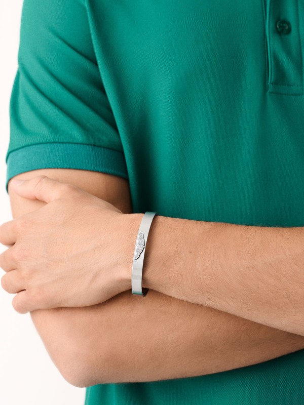 Aston Martin MJIBF5BM3 – elegantna muška narukvica izrađena od brušenog nerđajućeg čelika 316L u boji srebra. Ugravirana sa kultnim Aston Martin krilima, ova narukvica spaja snagu, luksuz i preciznost u savršenom balansu. Simbol britanske elegancije i performansi. Dimenzije (veličina M): 65 mm x 50 mm.