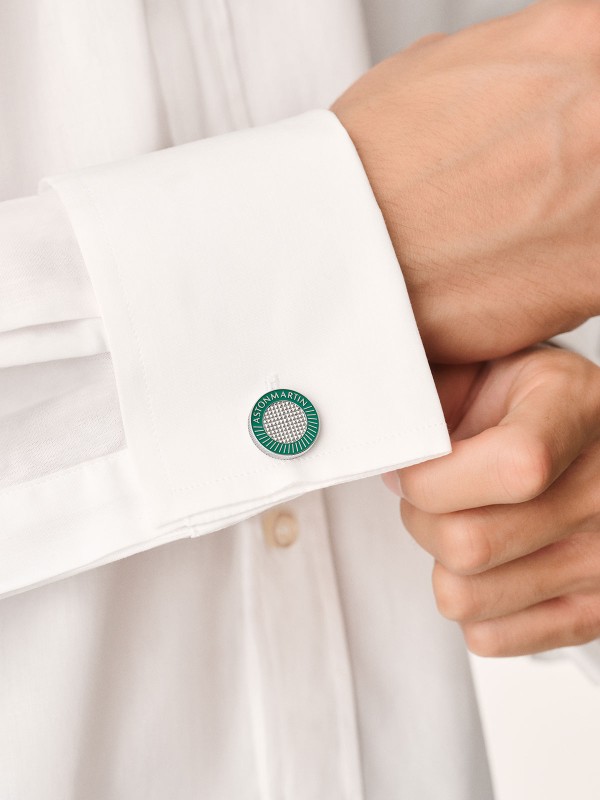 Aston Martin MJISF5CU6 – elegantna dugmad za manžetne izrađena od nerđajućeg čelika 316L sa ručno poliranim emajlom u boji srebra i podium zelenoj. Prepoznatljiv dizajn inspiriše se nasleđem britanskog luksuza i inženjerskom preciznošću Aston Martina. Suptilni, ali moćni simbol stila, performansi i sofisticiranosti – idealan dodatak modernom džentlmenu.