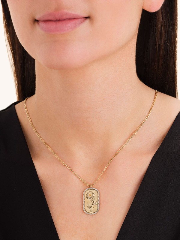 Duga ogrlica (69cm) u zlatnom tonu sa priveskom margarete i žutim cirkonom. Simbol čistoće i novih početaka.