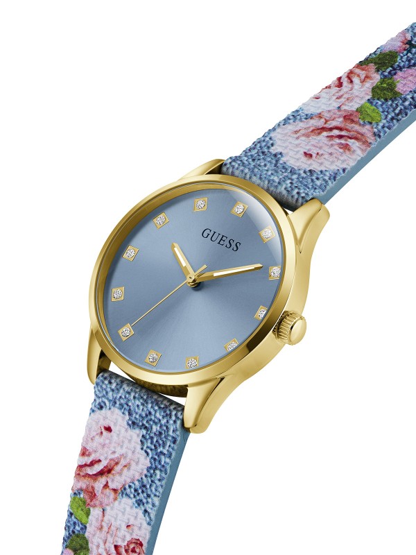 Ženski GUESS Marigold sat od 36mm u zlatnom tonu. Ledeno plavi brojčanik sa kristalima i plava silikonska narukvica sa cvetnim printom. Vodootporan do 30m.