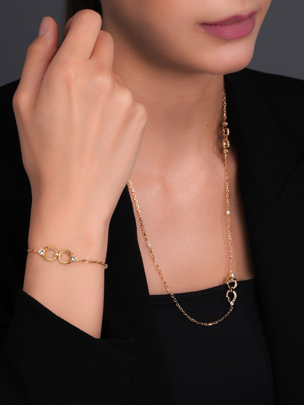 Elegantna CERRUTI 1881 Celeste ženska narukvica u zlatnom tonu sa logotipom C, cirkonima i biserom. Podesiva dužina 17+3,5cm od nerđajućeg čelika.